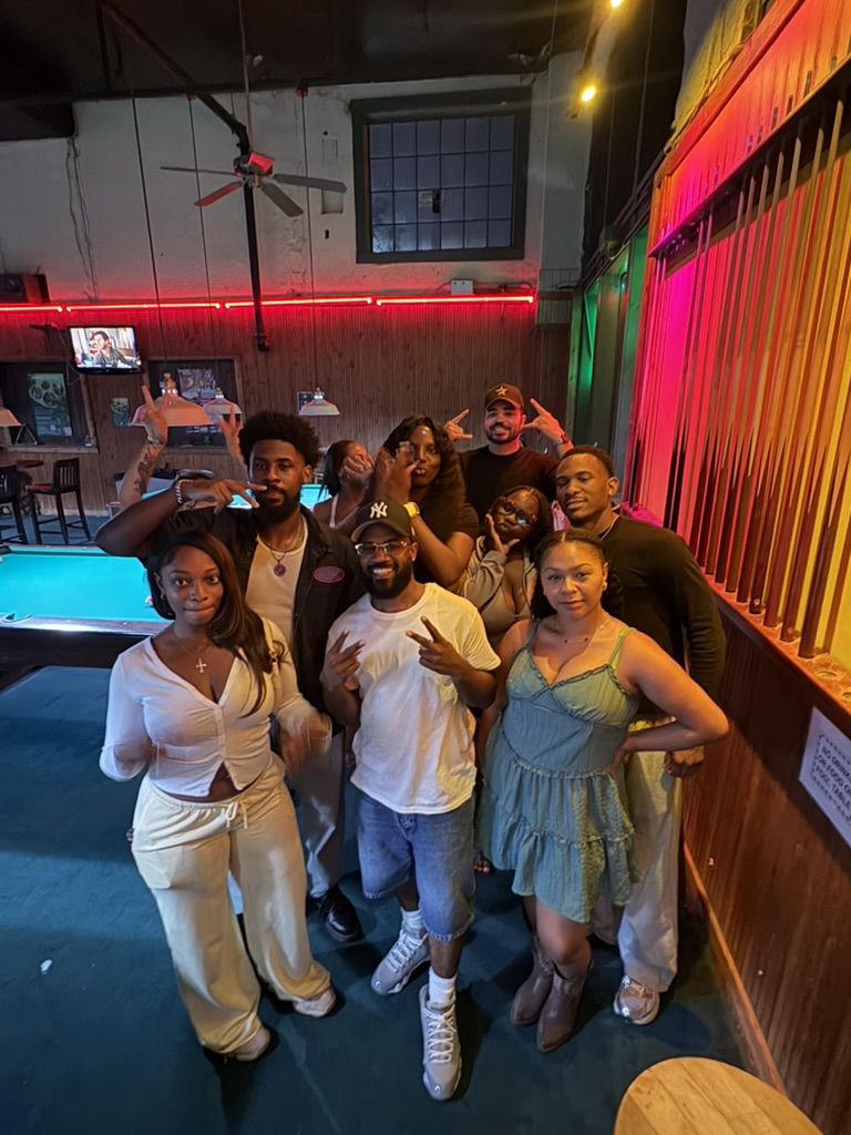 Members smiling together at a pool hall