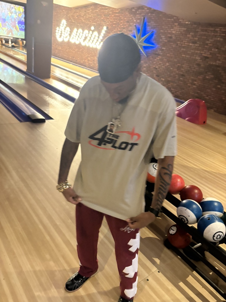A member showing off the 4ThePlot logo shirt at the bowling alley