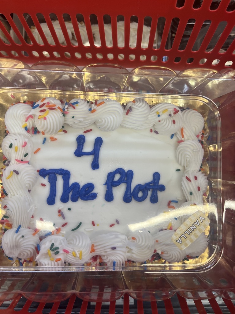 A cake with 4 The Plot written in blue icing